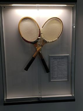 vanhoja tennismailoja esillä vitriinissä